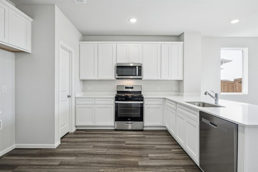 425 Magellan Road Seagoville, TX 75159 - Photo 4 of 36 a kitchen with granite countertop a stove and a sink