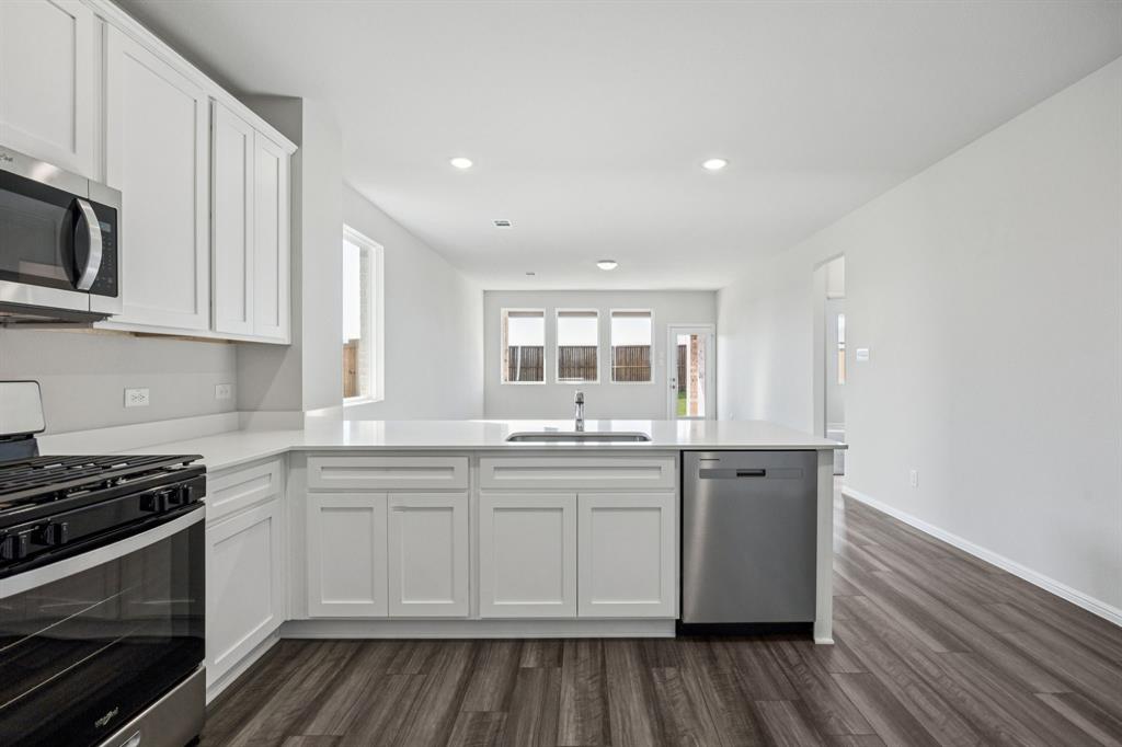 425 Magellan Road Seagoville, TX 75159 - Photo 6 of 36 a kitchen with stainless steel appliances granite countertop a stove and a sink