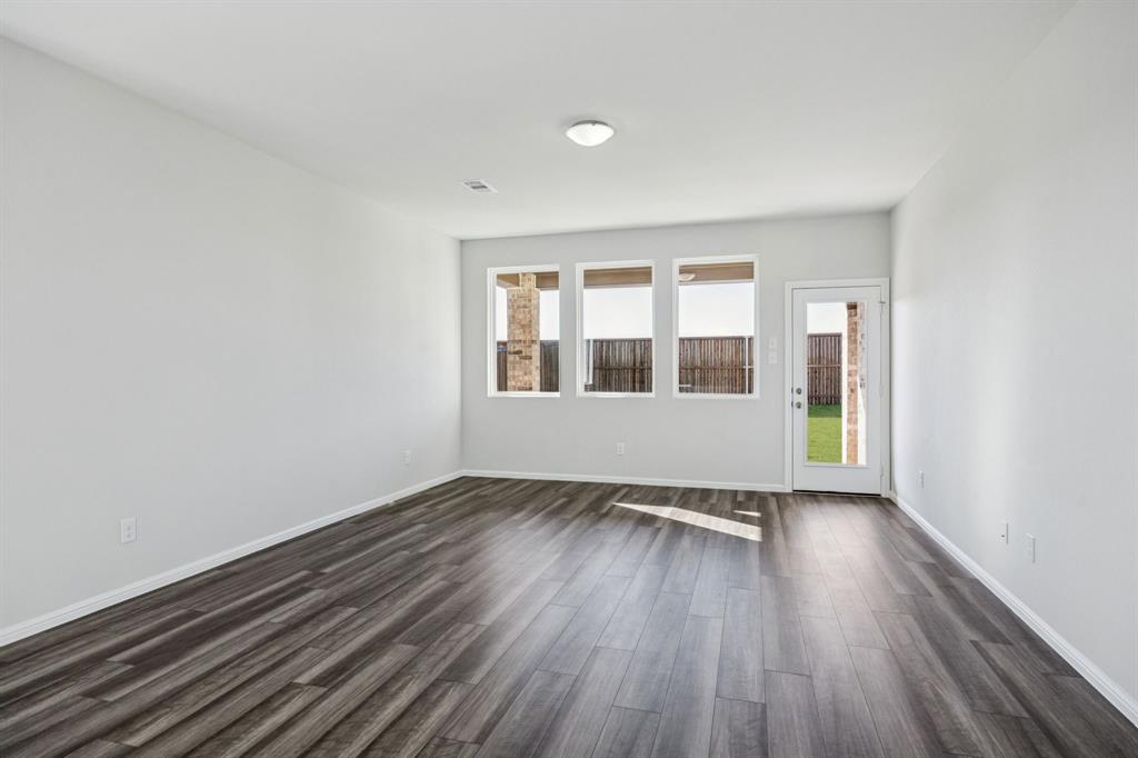 425 Magellan Road Seagoville, TX 75159 - Photo 8 of 36 a view of an empty room with wooden floor and a window