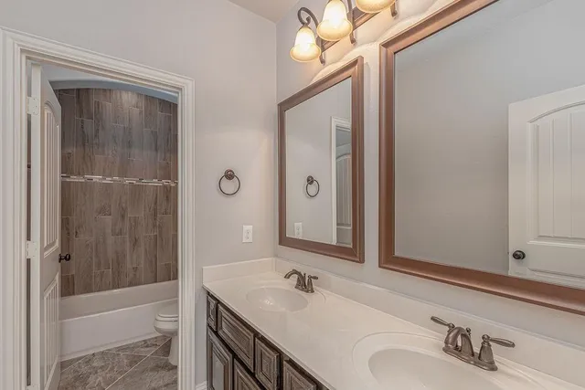 a bathroom with a tub a sink and mirror