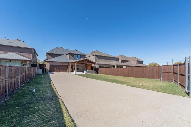 a view of a house with a yard and potted plants