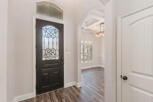 a view of a hallway with wooden floor and cabinet