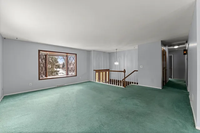 a view of empty room with window and wooden floor
