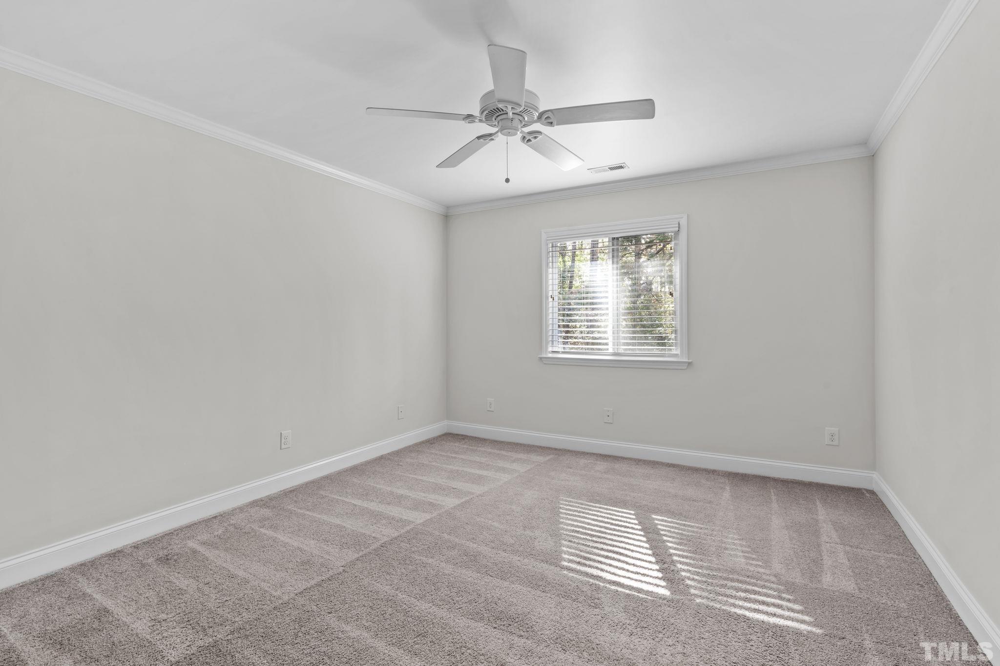 4505 Edwards Mill Road, Unit G Raleigh, NC 27612 - Photo 23 of 31 an empty room with a window and a ceiling fan