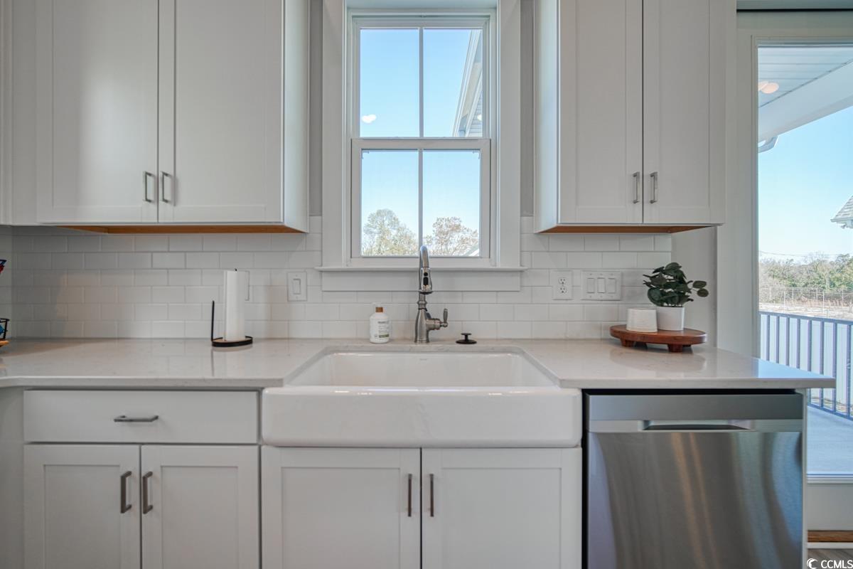 3810 Richardson Street Loris, SC 29569 - Photo 15 of 40 Kitchen with healthy amount of natural light, dishwasher, white cabinets, and backsplash