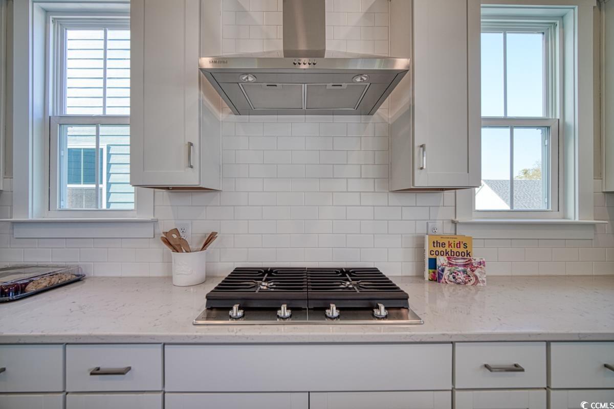 3810 Richardson Street Loris, SC 29569 - Photo 16 of 40 Kitchen with wall chimney range hood, light stone countertops, and decorative backsplash