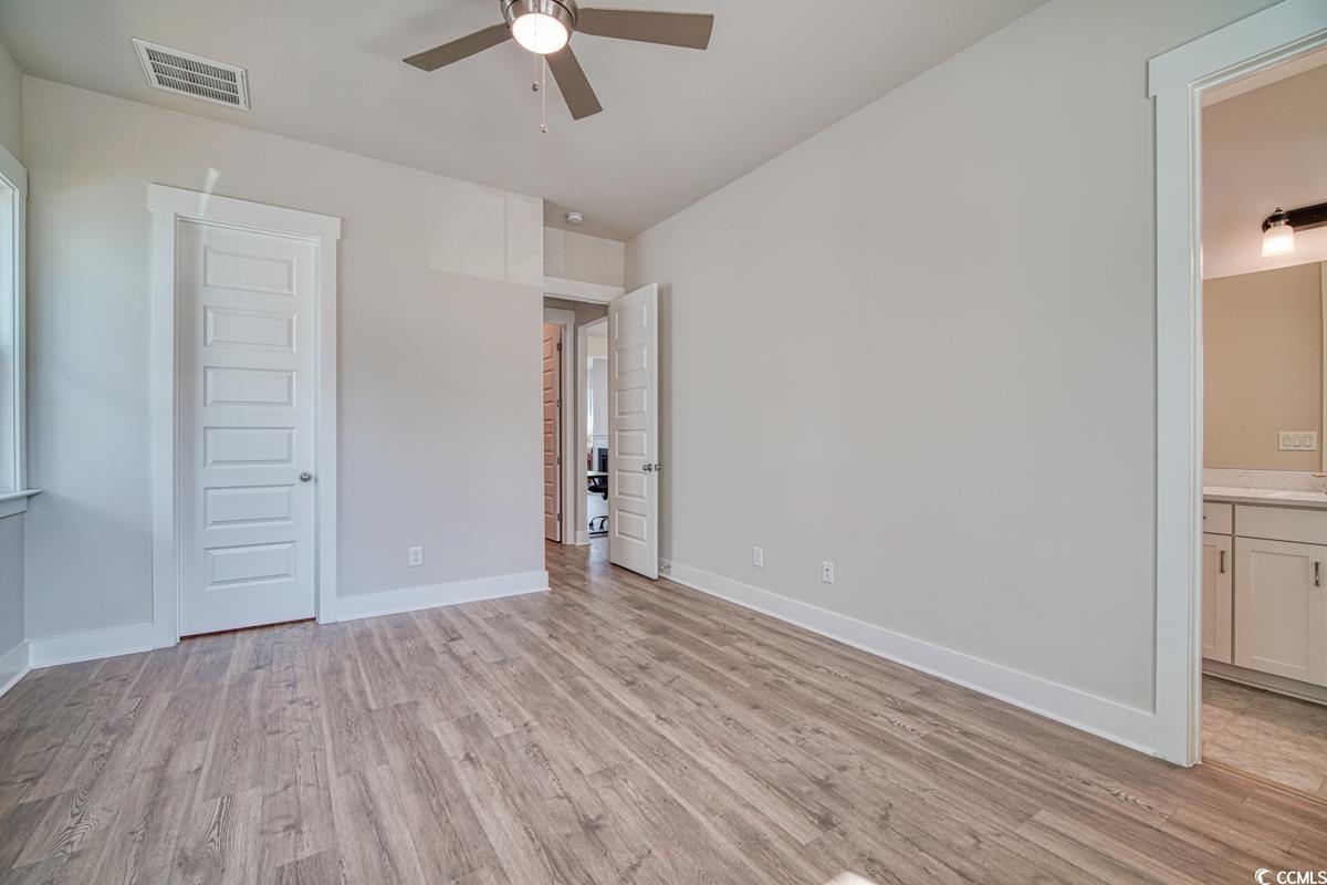 3810 Richardson Street Loris, SC 29569 - Photo 22 of 40 Unfurnished bedroom featuring light wood-type flooring, ceiling fan, and ensuite bath