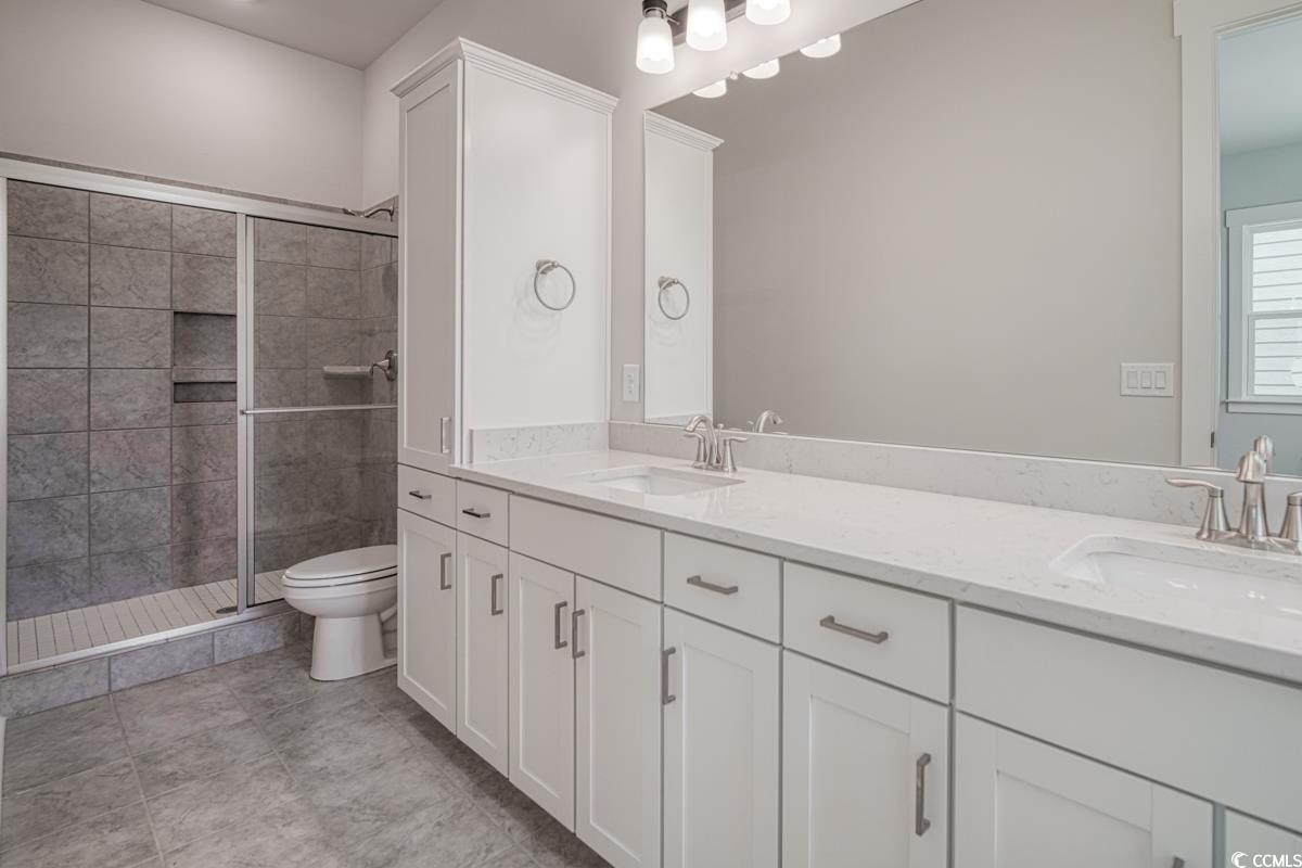 3810 Richardson Street Loris, SC 29569 - Photo 26 of 40 Bathroom featuring double vanity, a shower stall, and light tile patterned floors