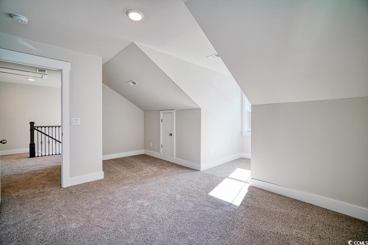 3810 Richardson Street Loris, SC 29569 - Photo 37 of 40 Bonus room with lofted ceiling and light colored carpet