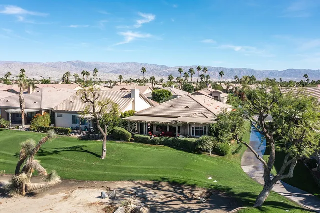 a living room with furniture a flat screen tv and a floor to ceiling window