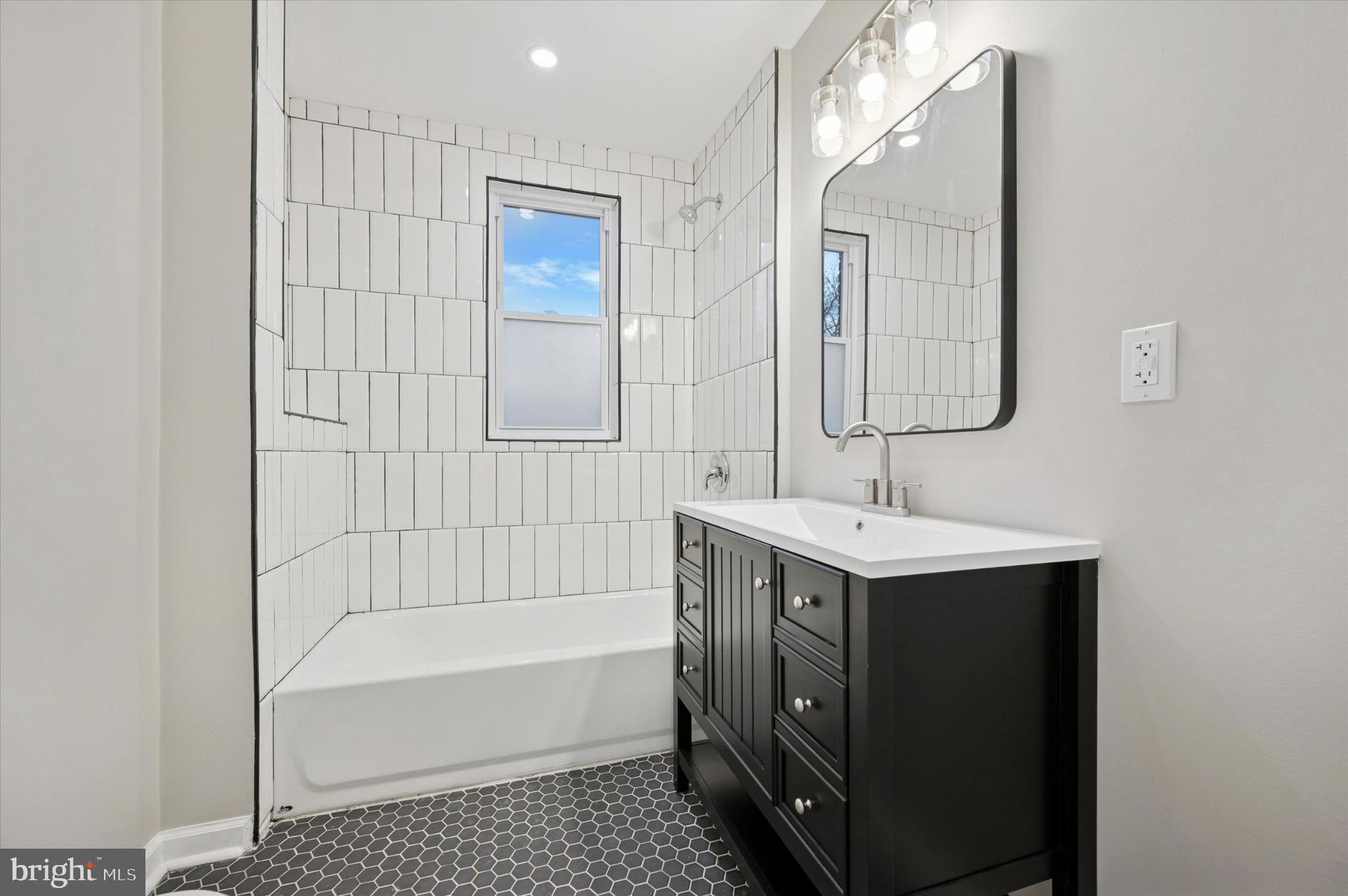 6416 North 15th Street Philadelphia, PA 19126 - Photo 14 of 23 a bathroom with a sink a mirror and a bathtub with shower