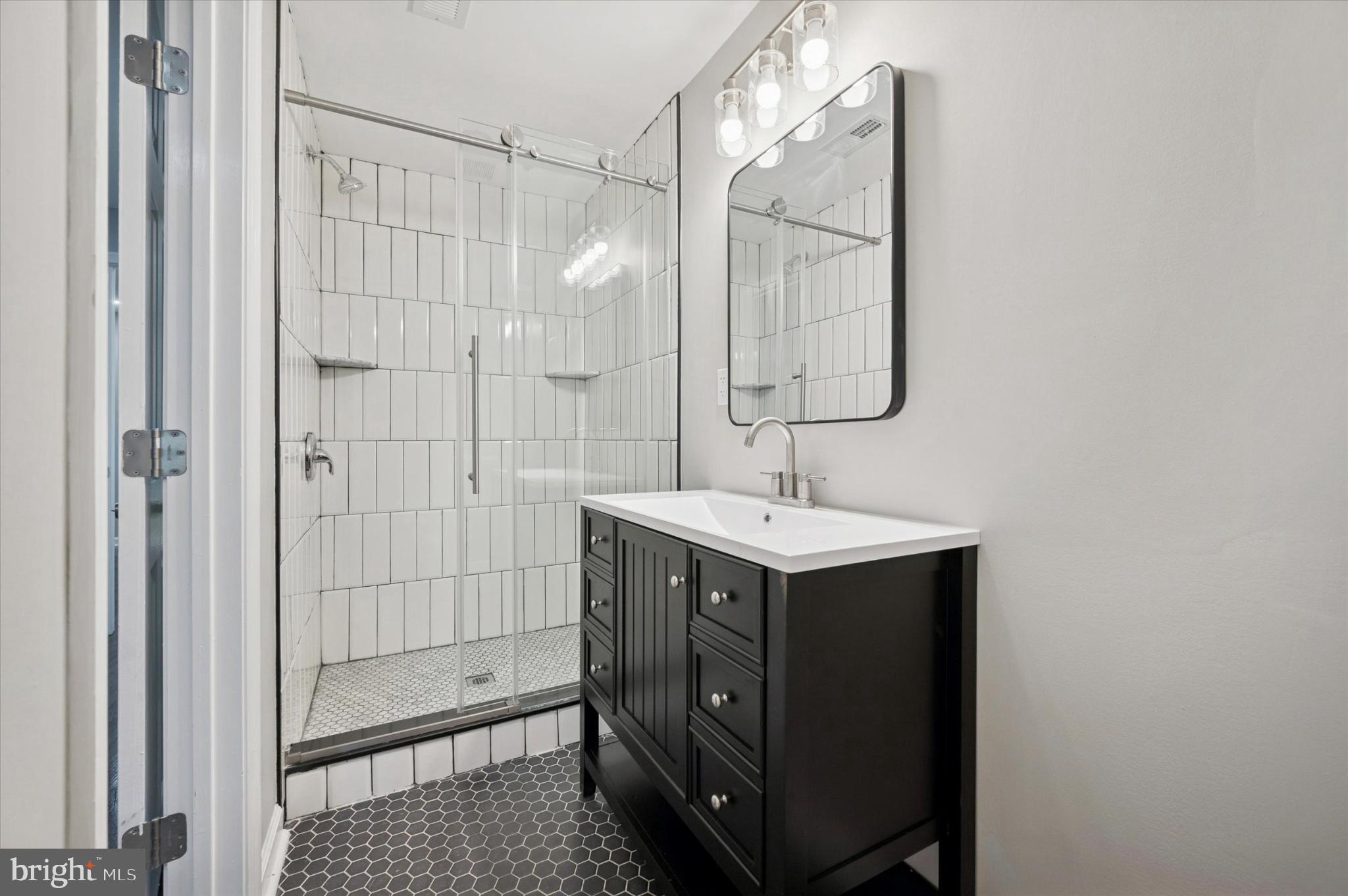 6416 North 15th Street Philadelphia, PA 19126 - Photo 22 of 23 a bathroom with a sink a mirror and shower