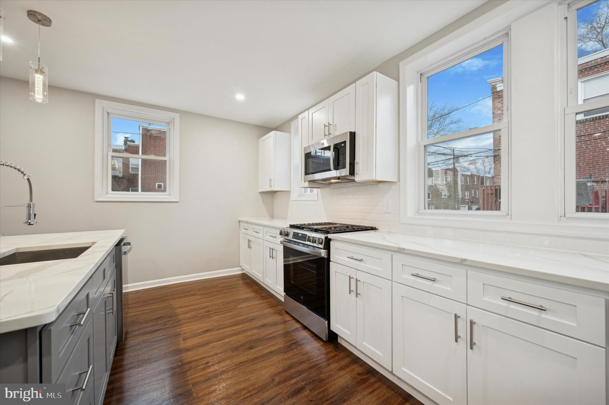 6416 North 15th Street Philadelphia, PA 19126 - Photo 9 of 23 a kitchen with granite countertop a sink wooden floor and stainless steel appliances