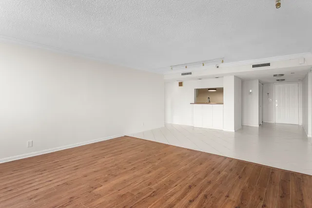 a view of empty room with wooden floor