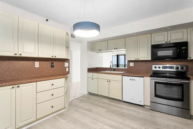 a kitchen with granite countertop a stove a sink and a microwave