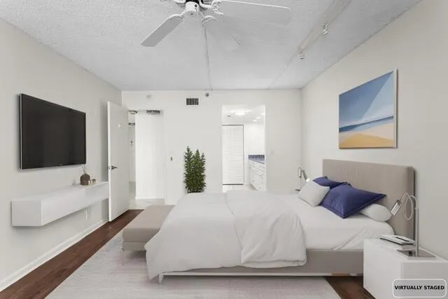 a spacious bedroom with a bed and a flat screen tv