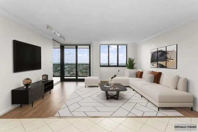 a living room with furniture a flat screen tv and a large window