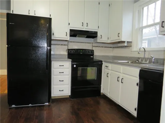 a kitchen with a refrigerator stove and white cabinets