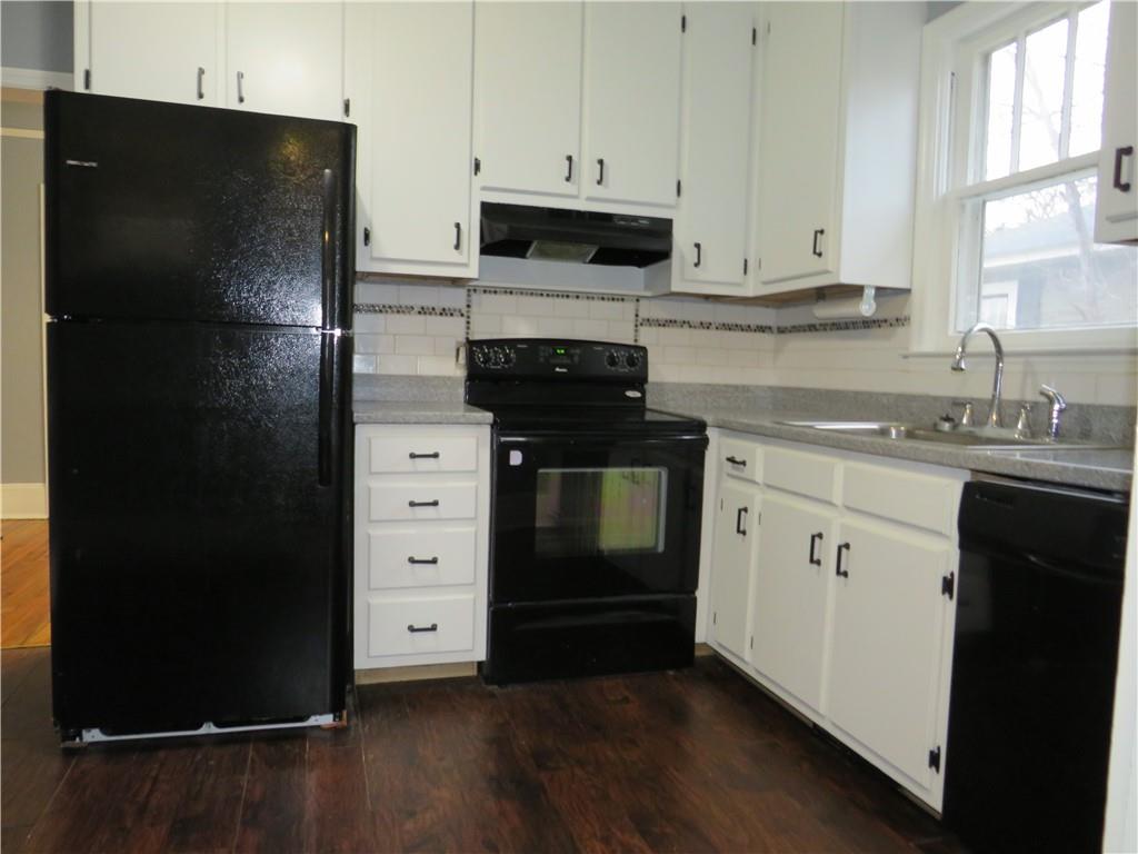 126 Marshall Street Cedartown, GA 30125 - Photo 12 of 12 a kitchen with a refrigerator stove and white cabinets