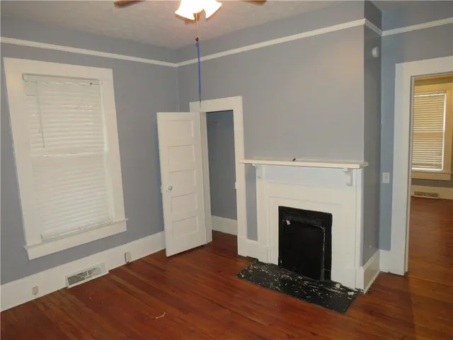 a view of empty room with wooden floor and fireplace