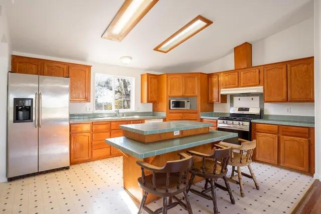 a kitchen with stainless steel appliances granite countertop a stove a sink and a refrigerator