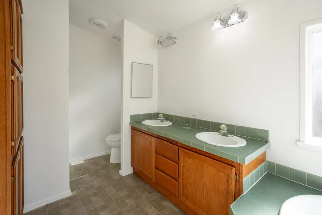 an empty room with a ceiling fan and a bathroom