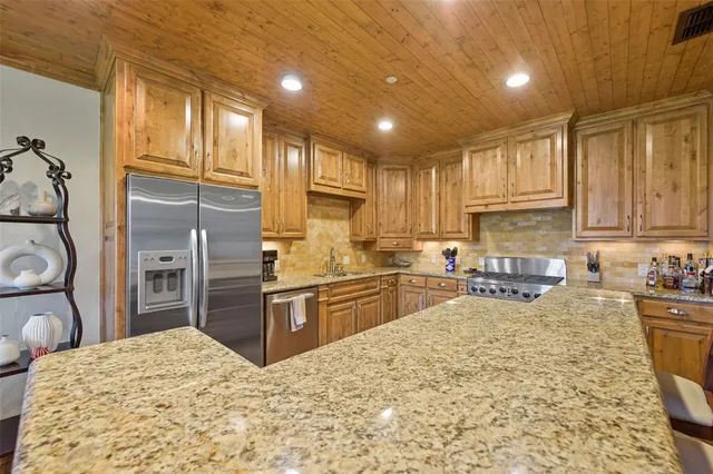 a kitchen with stainless steel appliances granite countertop a sink refrigerator stove and microwave