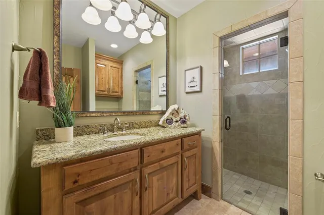 a bathroom with a granite countertop sink a mirror and a shower