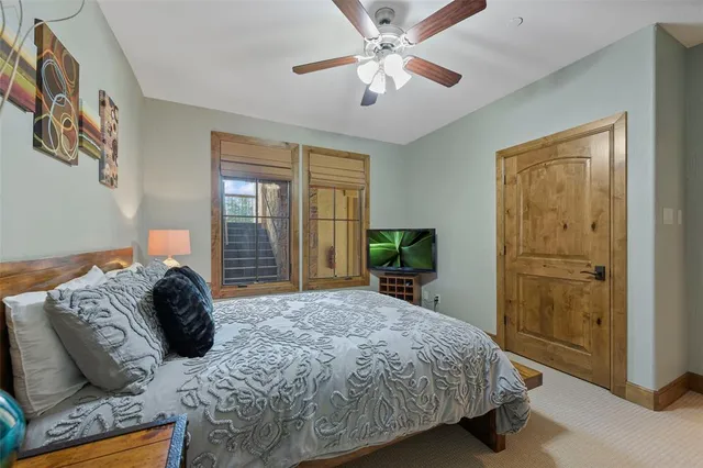 a bedroom with a bed lamp and a potted plant