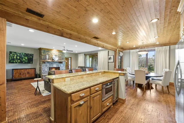 a view of a kitchen with kitchen island granite countertop a large counter top couches and stainless steel appliances