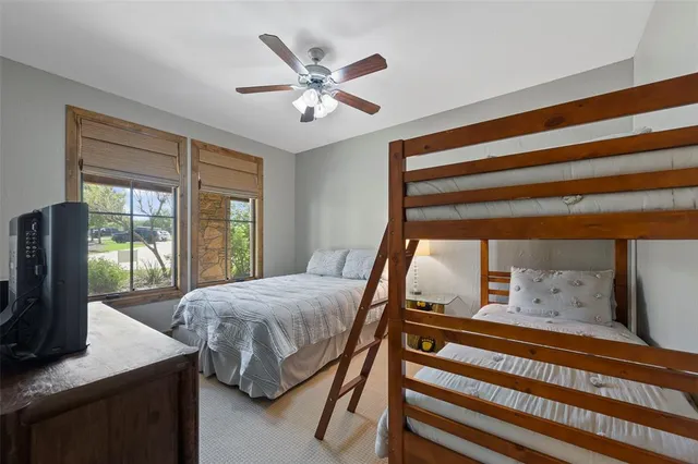 a bedroom with a bed and large windows