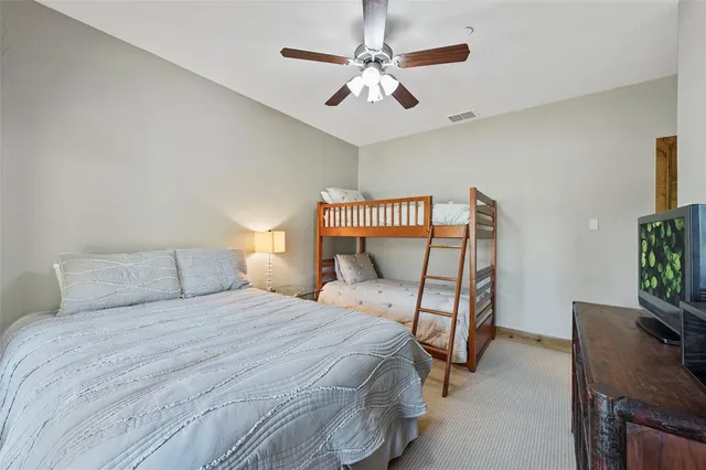 a bedroom with a bed a flat screen tv and a chandelier