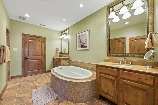 a bathroom with a tub sink and mirror