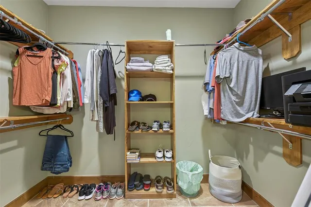 a view of walk in closet with clothes and shoes