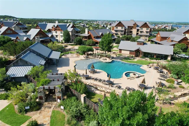an aerial view of residential houses with outdoor space and parking