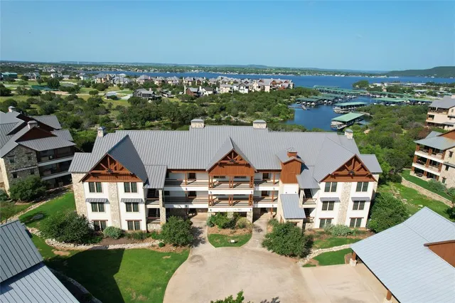an aerial view of residential houses with outdoor space and ocean view
