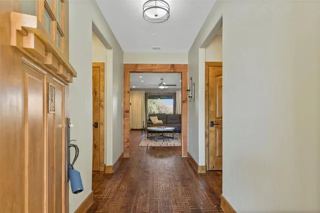 a view of a hallway with wooden floor and a bathroom