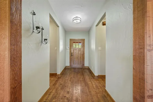 a view of a hallway with wooden floor and a bathroom