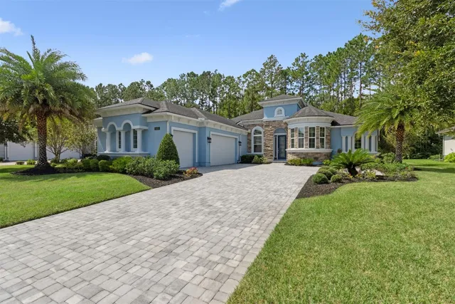 a front view of a house with a yard and trees