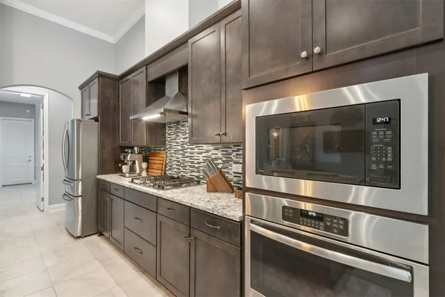 a large kitchen with granite countertop a sink and a large mirror with potted plant