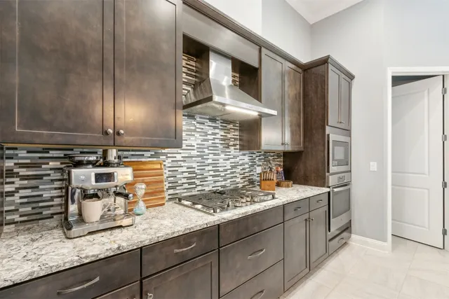 a kitchen with granite countertop a sink a stove and a refrigerator