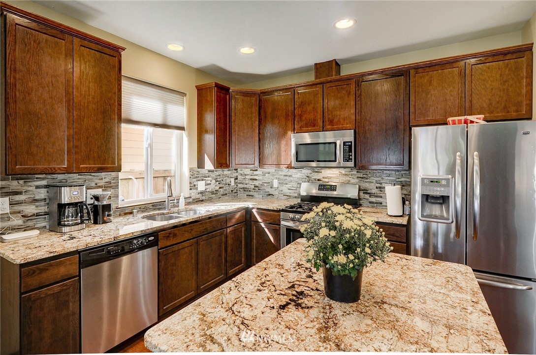 3424 189th Place Southeast Bothell, WA 98012 - Photo 8 of 16 a kitchen with stainless steel appliances granite countertop a sink stove refrigerator and cabinets