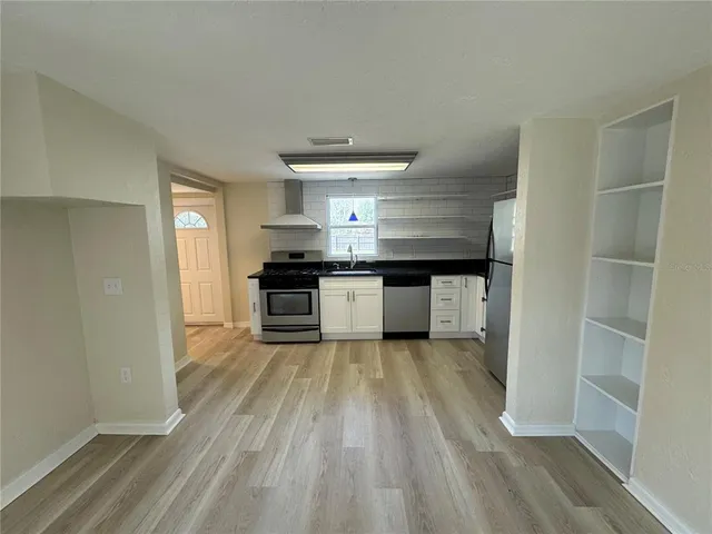 a kitchen with granite countertop a stove and a refrigerator