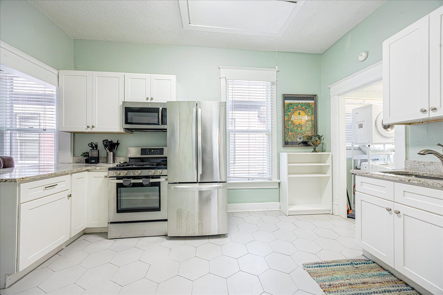 977 Philadelphia Street Memphis, TN 38104 - Photo 9 of 14 a kitchen with stainless steel appliances a refrigerator sink and microwave
