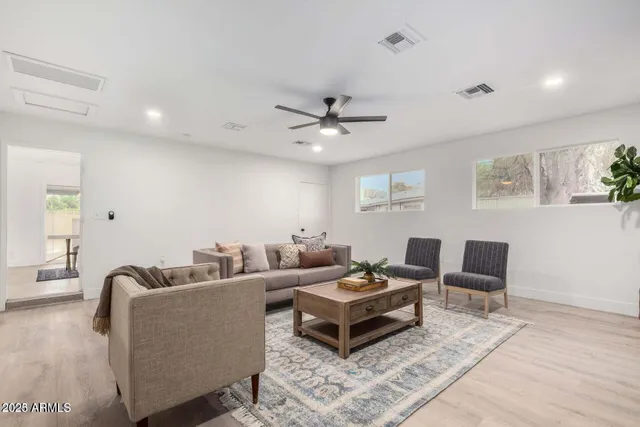 a living room with furniture and a ceiling fan