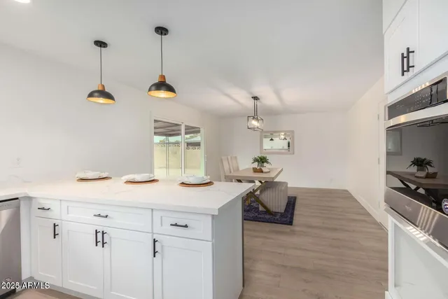 a kitchen with a sink a stove cabinets and wooden floor