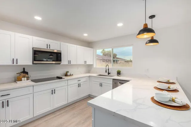 a kitchen with sink a microwave and cabinets