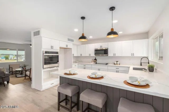 a kitchen with refrigerator a stove a dining table and chairs