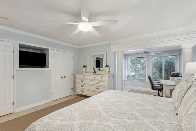 a bed room with a bed a television and large window