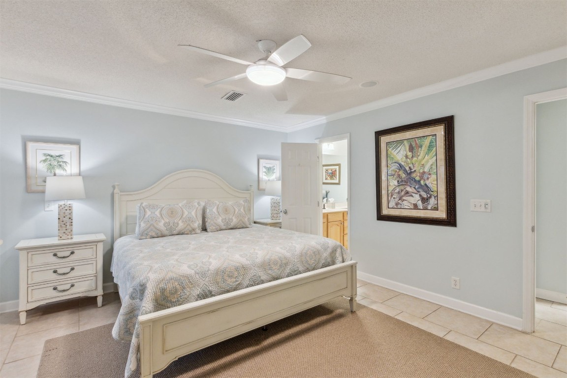 3323 Sea Marsh Road, Unit 3323 Fernandina Beach, FL 32034 - Photo 16 of 48 a bedroom with a large bed and a chandelier